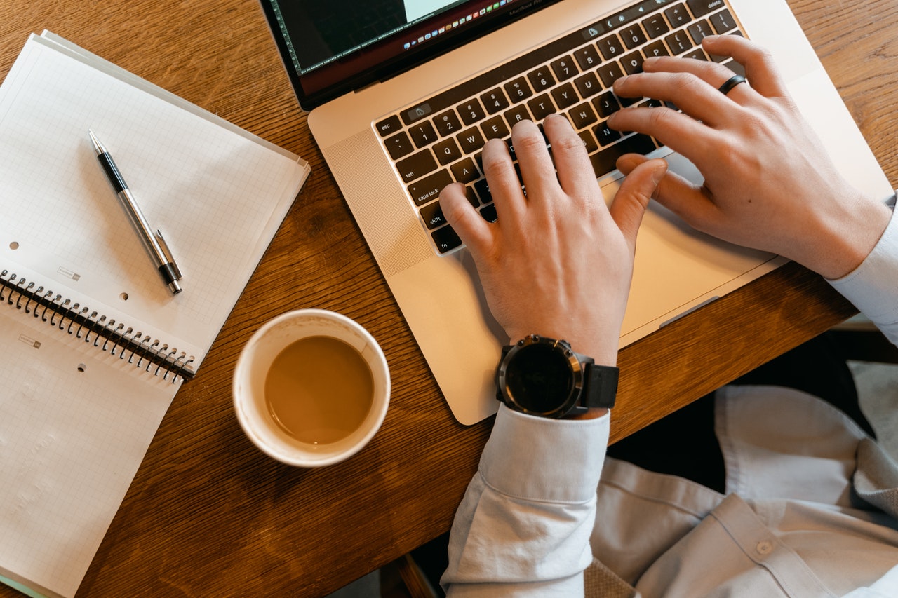 man typing on laptop keyboard computer